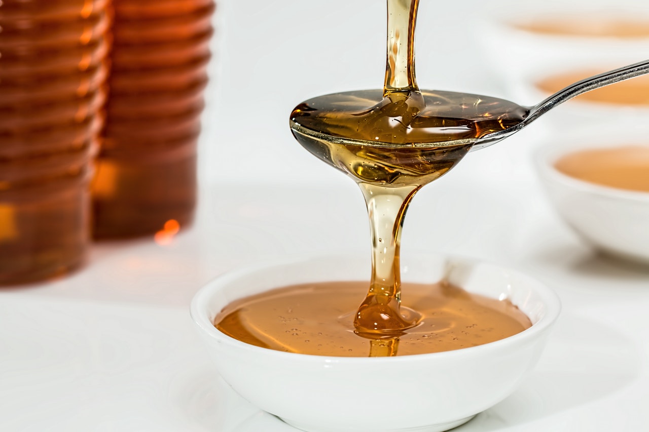 Pouring a raw honey on a spoon
